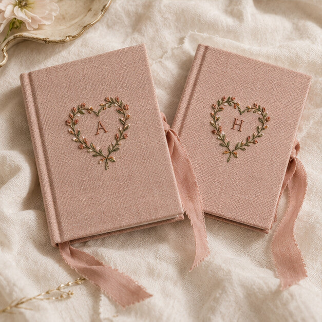 Blush linen vow books with embroidered monograms